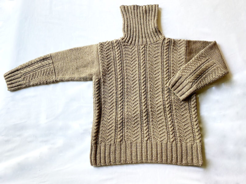 すももで染めた糸で編んだタートルネックのセーター